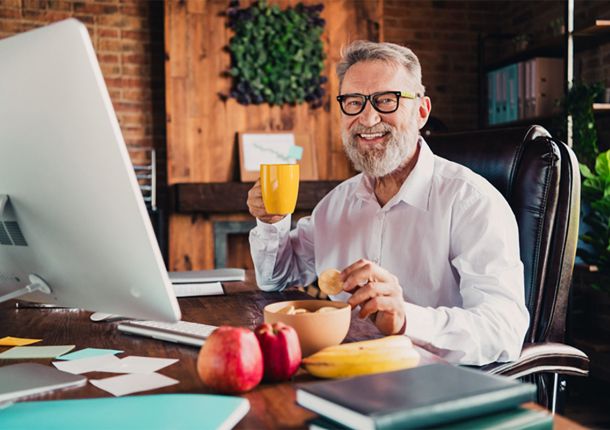 Senior sitzt zuhause im Büro und erzählt von seinem Sofortrenten-Gewinn bei Glöckle