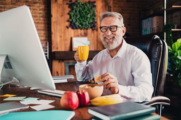 Senior sitzt zuhause im Büro und erzählt von seinem Sofortrenten-Gewinn bei Glöckle