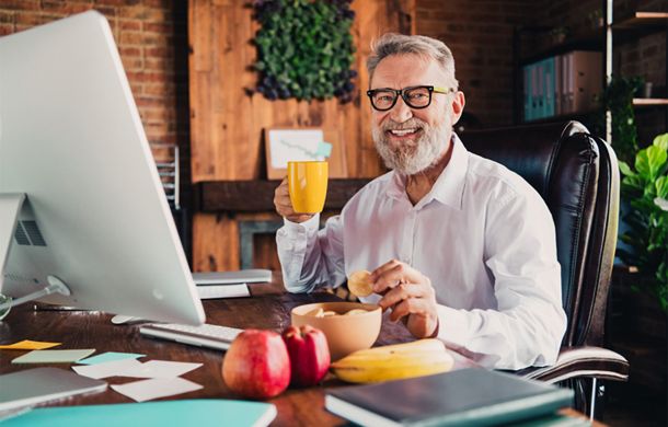 Senior sitzt zuhause im Büro und erzählt von seinem Sofortrenten-Gewinn bei Glöckle