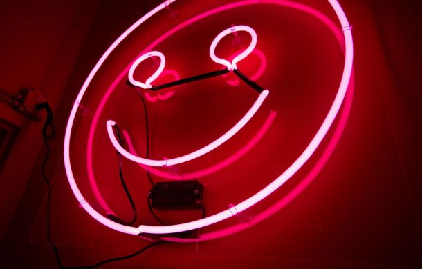 Leuchtende LED-Lampe in Pink, an einer Wand angebracht.