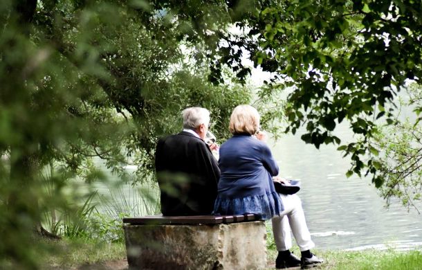 Älteres Ehepaar auf einer Bank am See