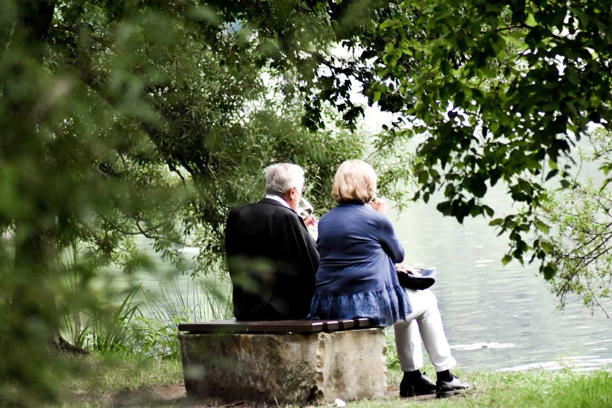 Älteres Ehepaar auf einer Bank am See