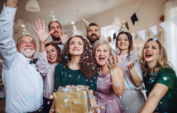 Ein Porträt einer Mehrgenerationenfamilie mit Geschenken, die auf einer Geburtstagsfeier im Haus stehen.