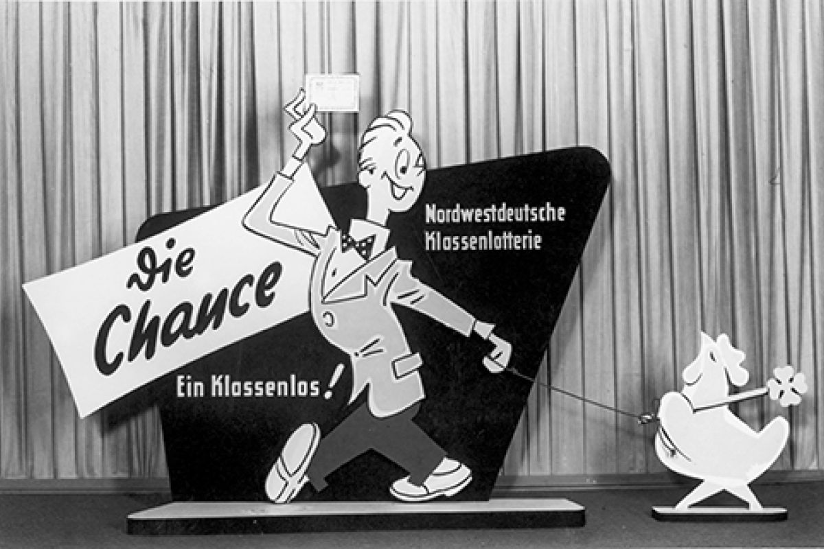 Pappschild zur Nordwestdeutschen Klassenlotterie, mit einer männlichen Figur, die ein Los in der Hand hält.